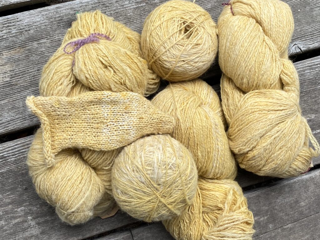 pale yellow alpaca yarn on a wood deck