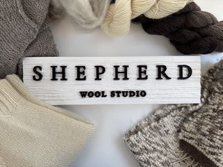 business name black text on white background surrounded by natural colour wool knit items